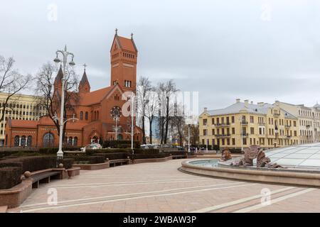 Minsk, Biélorussie - 3 janvier 2024 : vue sur la place de l'indépendance avec l'église rouge en arrière-plan. Les touristes marchent dans la rue Banque D'Images