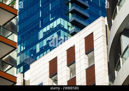 Architecture contrastée avec un ancien bâtiment flanqué de hauts-tours modernes en verre sous un ciel bleu Banque D'Images