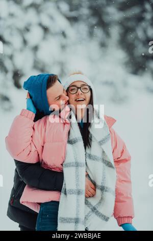 Lors d'une Saint-Valentin enneigée, ce couple romantique partage chaleur, rires et tendres étreintes, créant une histoire d'amour hivernale heureuse. Banque D'Images