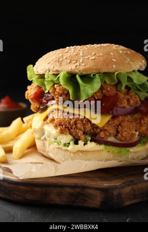 Délicieux Burger avec patty de poulet croustillant et frites sur la table, gros plan Banque D'Images