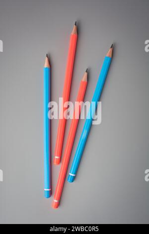 gros plan de bouquet de crayons, crayons en bois aiguisés bleu et rose couleurs crayons inutilisés dispersés et isolés sur fond gris neutre, papeterie Banque D'Images