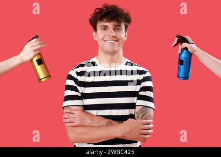 Beau jeune homme et mains féminines avec des bouteilles de spray pour cheveux sur fond rouge Banque D'Images