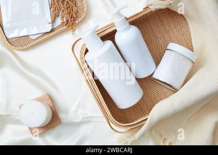 Photo publicitaire pour cosmétique et produit avec concept de salle de bain. Deux pompes bouteille blanche sans marque et pot de bain de sel sur panier en bambou décoré avec Banque D'Images