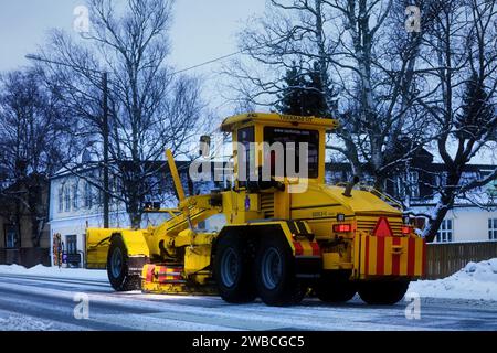 Niveleuse jaune Veekmas FG 2327 S enlevant la neige de la rue avec lame réglable après la chute de neige hivernale, vue arrière. Salo, Finlande. 29 décembre 20 Banque D'Images