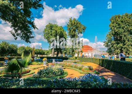 St. Pétersbourg, Russie - 23 août 2023 : fontaines de Peterhof. Vue du palais Monplaisir dans le parc inférieur de Peterhof. Beau jardin avec herbe verte, arbustes et fleurs et arbres décoratifs Banque D'Images