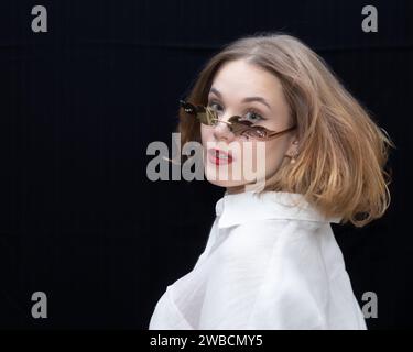 Jeune fille tourne la tête en arrière et regarde la caméra Banque D'Images