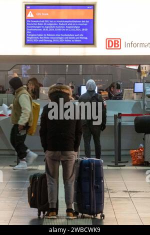 10 janvier 2024, Hesse, Francfort-sur-le-main : les voyageurs se tiennent devant un bureau d'information. Le syndicat allemand des conducteurs de train (GDL) a appelé à la première grève de plusieurs jours dans le conflit salarial actuel avec Deutsche Bahn et d'autres entreprises à partir du milieu de la semaine. Photo : Helmut Fricke/dpa Banque D'Images