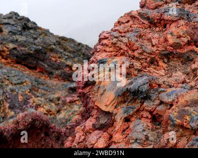 Roche volcanique de couleur rouge au sommet du cratère Dolomieu, Piton de la Fournaise, Réunion Banque D'Images