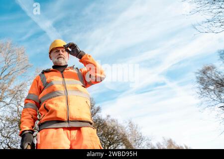 Le constructeur défonce la route en posant des goupilles en acier avec un marteau en morceaux pendant les travaux routiers. Constructeur martelant des barres d'acier dans l'asphalte pendant le roadwor Banque D'Images