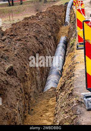 Nouvelle conduite d'eau en plastique dans la tranchée. Remplacement des vieux tubes rouillés par un nouveau Banque D'Images