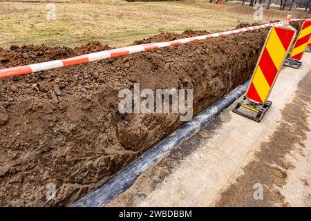 Nouvelle conduite d'eau en plastique dans la tranchée. Remplacement des vieux tubes rouillés par un nouveau Banque D'Images