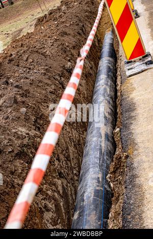 Nouvelle conduite d'eau en plastique dans la tranchée. Remplacement des vieux tubes rouillés par un nouveau Banque D'Images