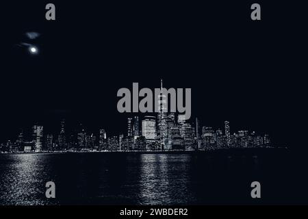 Une superbe photographie en noir et blanc du paysage urbain de New York la nuit, illuminée par les lumières Banque D'Images