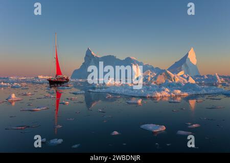 Naviguer sous le soleil de minuit dans la baie de Disko au Groenland. Banque D'Images