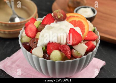 Un bol de fruits frais tranchés avec garniture au yaourt grec, concept de régime alimentaire sain de salade de fruits Banque D'Images