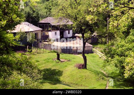 Comté de Vrancea, Roumanie, env. 1990. Une propriété rurale avec petite maison traditionnelle et grange. Banque D'Images