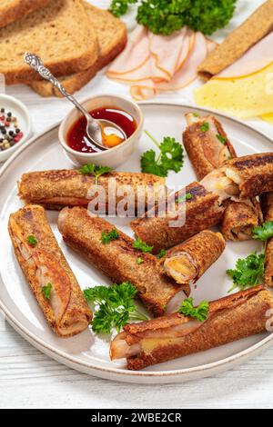 pain grillé français au jambon et au fromage au blé entier servi avec une sauce chili sucrée sur une assiette sur une table en bois blanc avec des ingrédients à l'arrière-plan, à la verticale Banque D'Images