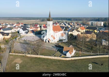 Ralbitz, Allemagne. 09 janvier 2024. Des croix tombales se dressent dans un cimetière en face de l'église de la paroisse de 'Sankt Katharina' Ralbitz (vue aérienne avec un drone). Crédit : Sebastian Kahnert/dpa/Alamy Live News Banque D'Images