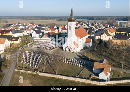 Ralbitz, Allemagne. 09 janvier 2024. Des croix tombales se dressent dans un cimetière en face de l'église de la paroisse de 'Sankt Katharina' Ralbitz (vue aérienne avec un drone). Crédit : Sebastian Kahnert/dpa/Alamy Live News Banque D'Images