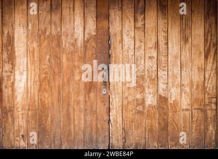 Porte fermée en bois faite de palettes lavées en bois avec une serrure au milieu. Une gamme de textures est visble grâce aux matériaux en bois. Banque D'Images