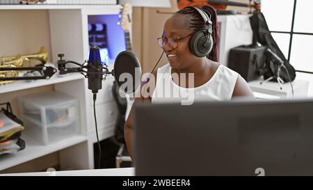 Journaliste afro-américaine portant des écouteurs présentant des nouvelles au studio de radio Banque D'Images