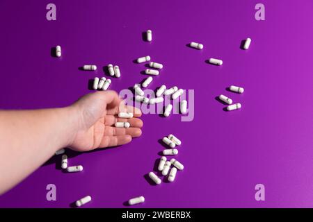 Pilules de complément alimentaire sur fond violet Banque D'Images