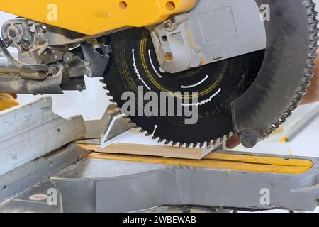 Chop Saw est utilisé pour couper les moulures de base en bois du projet d'amélioration de la maison Banque D'Images