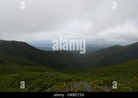 Une vue panoramique sur une chaîne de montagnes avec des collines et des pentes couvertes d'herbe verte luxuriante ci-dessous Banque D'Images