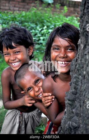 Portrait de deux enfants jouant à cache-cache dans les bidonvilles de rayer bazar. Bangladesh. Banque D'Images
