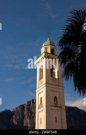 Clocher de l'église de San Zenone contre le ciel bleu et le pic de montagne San Salvatore et Palm Leaf à Campione d'Italia, Lombardie, Italie Banque D'Images