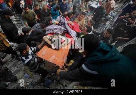 Les Palestiniens portent le corps d’un enfant qui a été retrouvé sous les décombres de sa maison à Khan Yunis, au sud de la bande de Gaza. Palestine. Banque D'Images