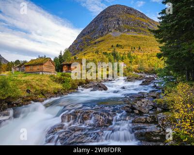 Automne à Valldalen, cabanes au bord d'une rivière en face d'une montagne, parc national de Reinheimen, More og Romsdal, Norvège Banque D'Images