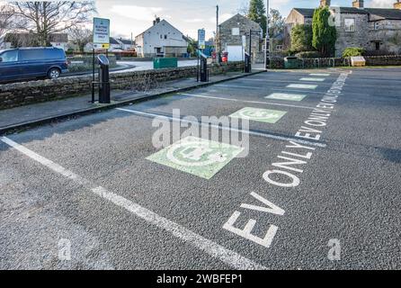 Gargrave, North Yorkshire Empty EV seulement les places dans une aire de stationnement autrement pleine---préparer pour l'avenir, Banque D'Images