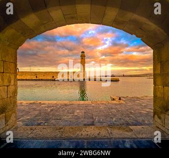 Le phare égyptien de l'ancien port de Rethimno à travers un cadre d'une porte voûtée, Crète, Grèce. Banque D'Images