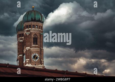 Une tour d'horloge majestueuse se dresse contre un ciel nuageux, avec des nuages sombres imminents en arrière-plan Banque D'Images