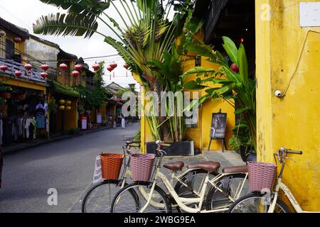 Ruelle dans la ville asiatique (Hoi-an) avec des lanternes et vélo en face Banque D'Images