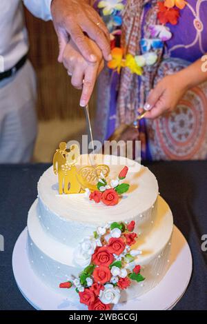 gâteau de mariage blanc avec des poupées représentant la mariée et le marié sur le dessus. Banque D'Images