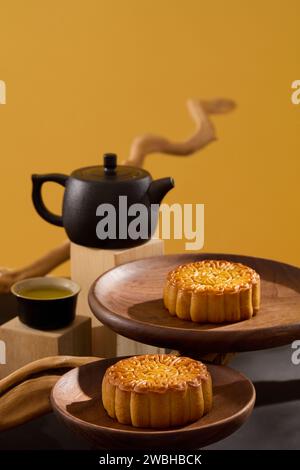 Fête de la mi-automne avec de délicieux gâteaux de lune présentés sur quelques plats ronds. Théière noire et tasse de thé sont disposés. Joyeux mi-automne Banque D'Images