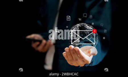 Concept de communication en ligne, nouvelle icône de message, main d'homme d'affaires à l'aide de smartphone pour e-mail et notifications. Banque D'Images