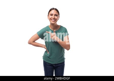 active souriante jeune femme brunette caucasienne en t-shirt vert attire l'attention Banque D'Images