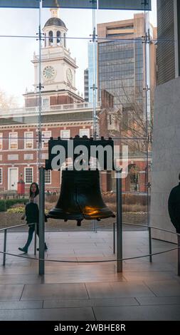 Touristes visitant la Liberty Bell à Philadelphie, Pennsylvanie, avec Independence Hall en arrière-plan Banque D'Images