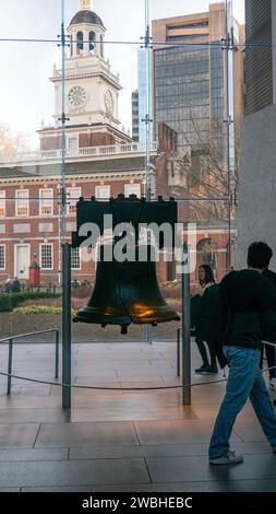 Touristes visitant la Liberty Bell à Philadelphie, Pennsylvanie, avec Independence Hall en arrière-plan Banque D'Images