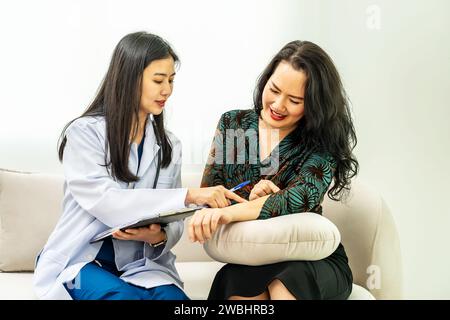 La femme rend visite à un jeune médecin cosmétologue. Le médecin consulte le patient, écoutant les recommandations sur les soins de la peau, les étapes à la perfection: Banque D'Images