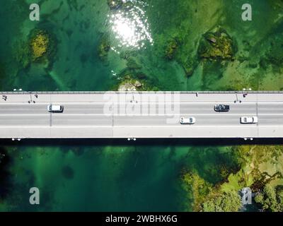 Pont au-dessus de la belle rivière verte, vue aérienne drone. Voitures et piétons se déplaçant sur le pont asphalté, vue de dessus. Transport. Pont en béton Banque D'Images