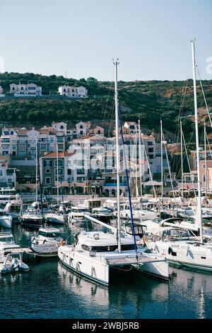 Des voiliers bordent la jetée devant des maisons colorées. Port de plaisance de Lustica Bay, Monténégro Banque D'Images