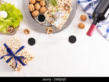 Matzoth, bouteille rouge de vin casher, noix sur un plateau en argent, herbes et œuf. Nourriture traditionnelle pour la célébration de la Pâque juive Banque D'Images