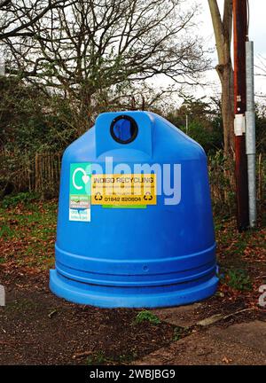 Un conteneur bleu pour la collecte de matériaux de recyclage par le staithe sur la rivière Ant sur les Norfolk Broads à Irstead, Norfolk, Angleterre, Royaume-Uni. Banque D'Images