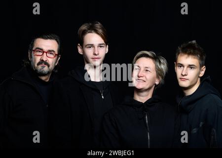 photo de studio de quatre personnes portant des vêtements noirs sur le fond noir Banque D'Images