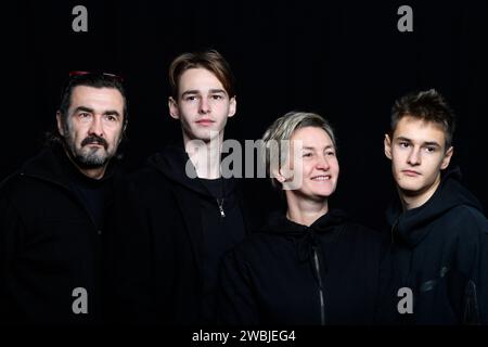 photo de studio de quatre personnes portant des vêtements noirs sur le fond noir Banque D'Images