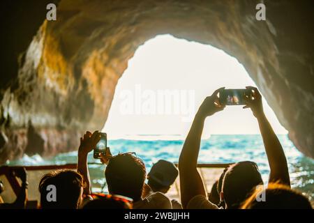 Visites touristiques et prendre des photos avec des smartphones à l'intérieur de la grotte sur la côte de l'Algarve, Albufeira, Portugal Banque D'Images